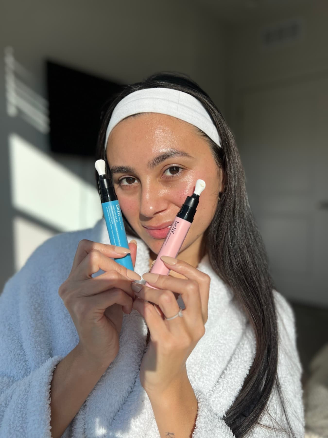 Julia Jones holding belif products in a bright skincare routine portrait