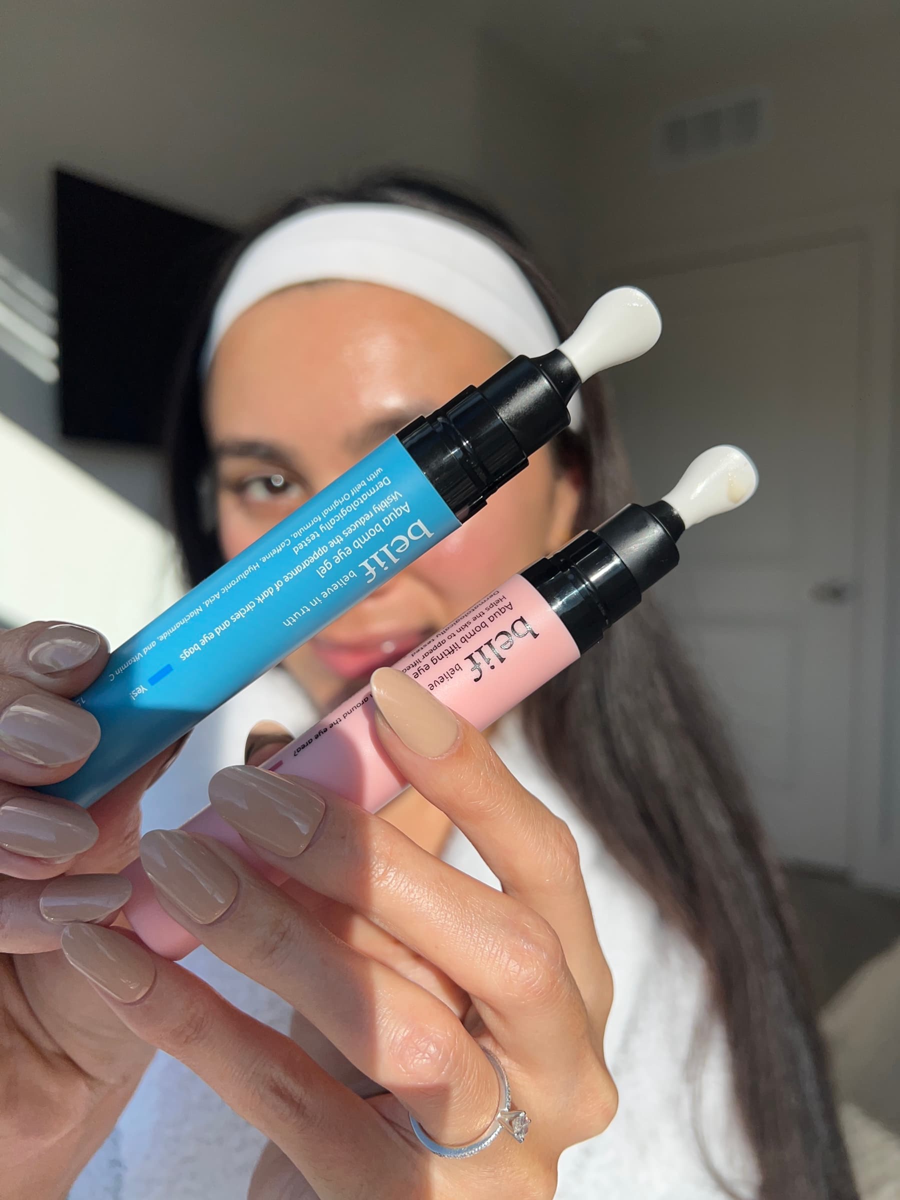 Julia Jones holding belif skincare serums close to the camera